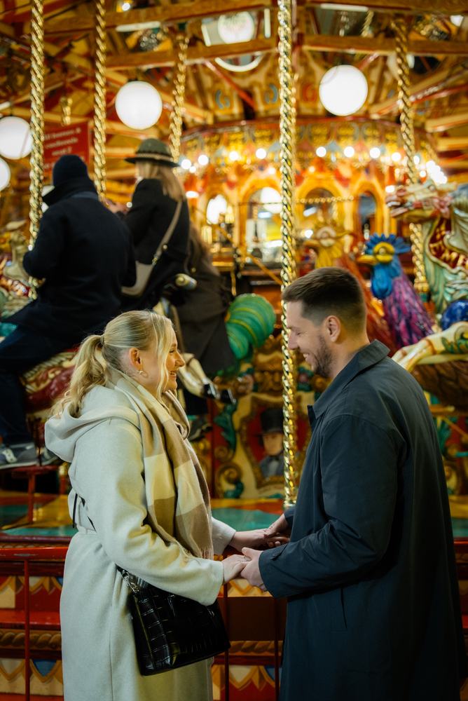 Couple by a lit-up carousel