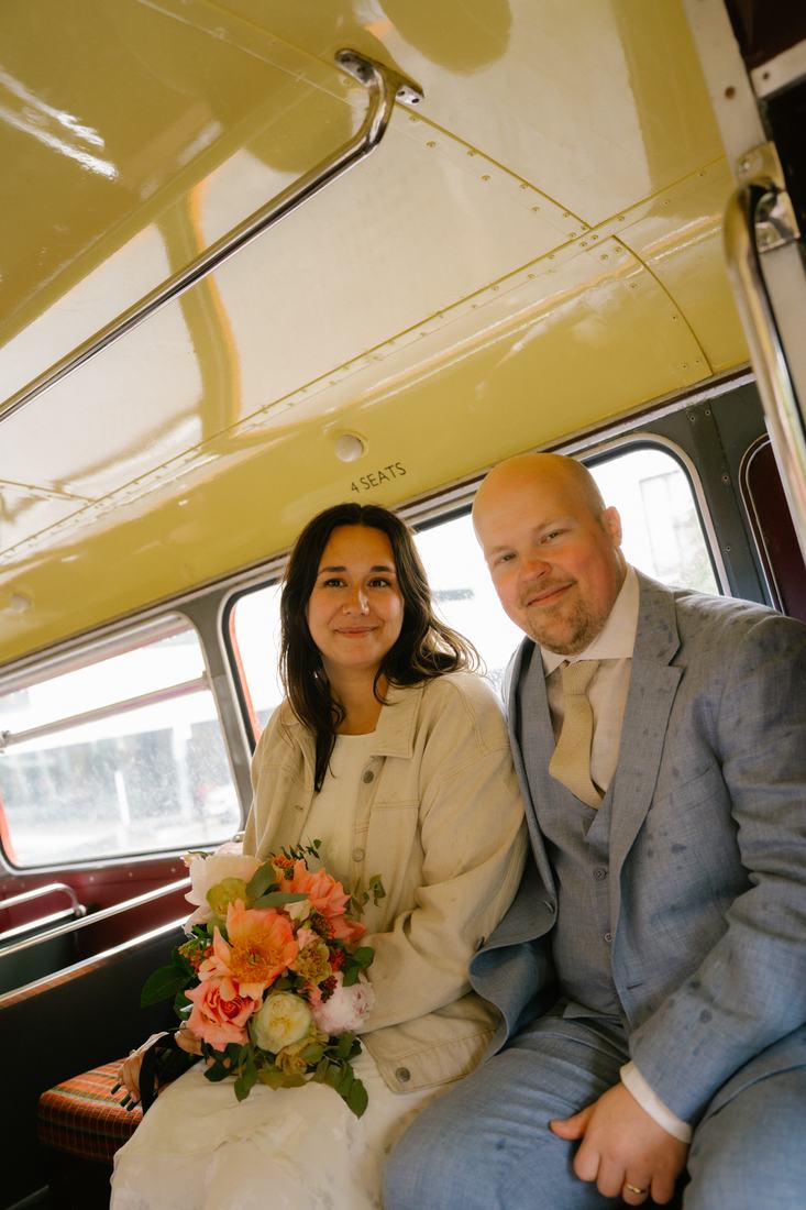 Newlyweds on the top deck of a vintage bus