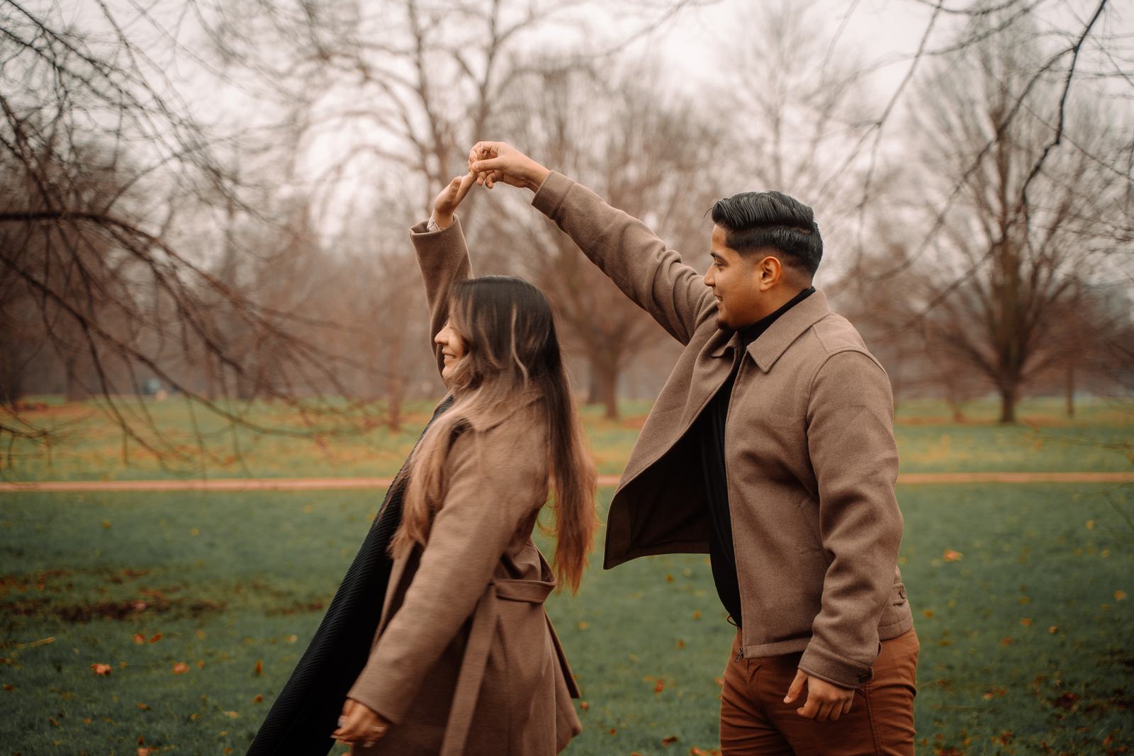 Couple twirling in the park after the proposal