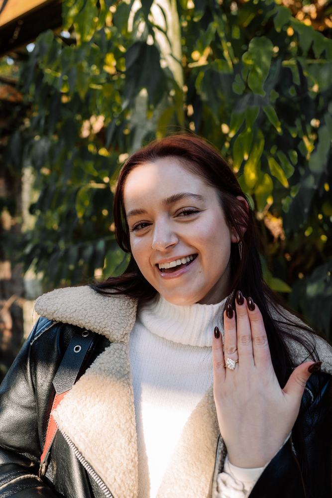Woman beaming, showing her new ring