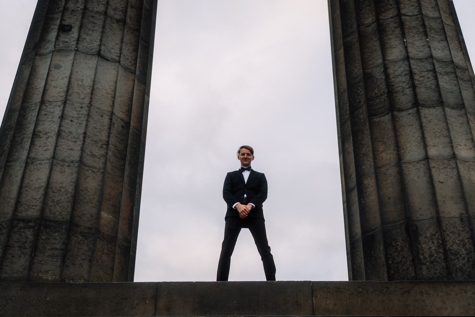 Groom standing between the columns of the National Monument