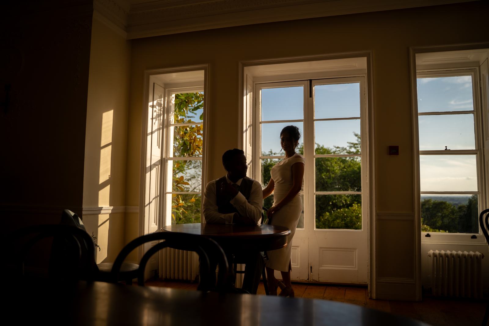 Couple silhouetted by tall windows
