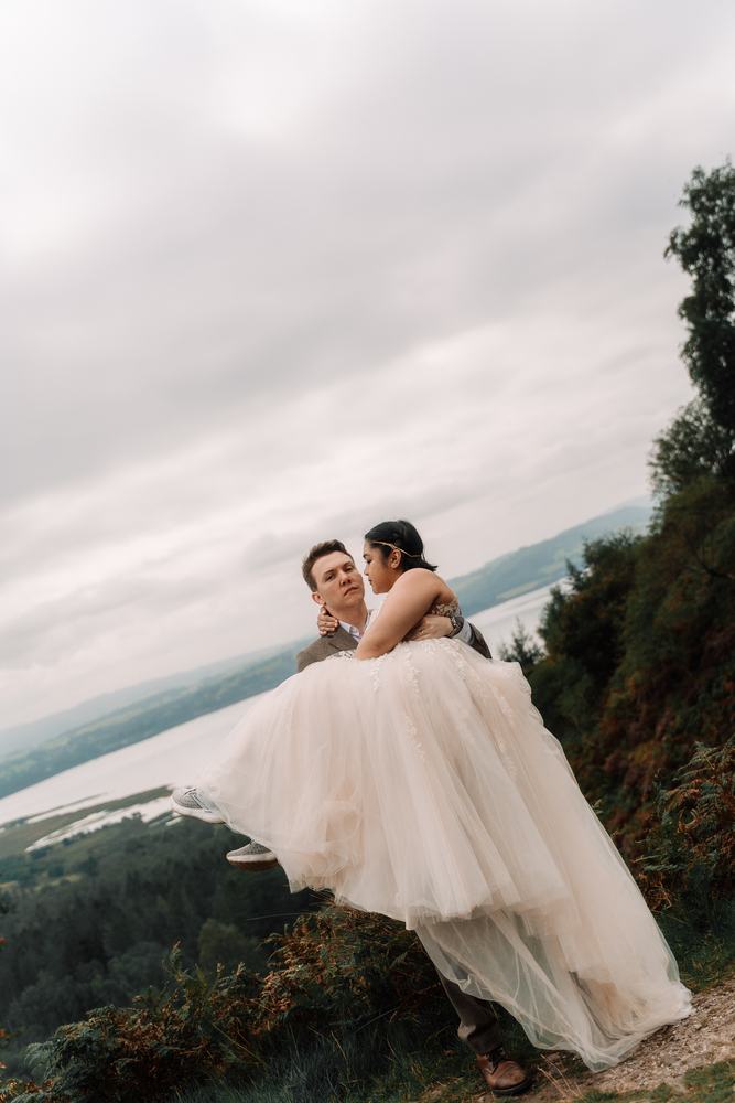 Bride and groom on a clifftop above a loch