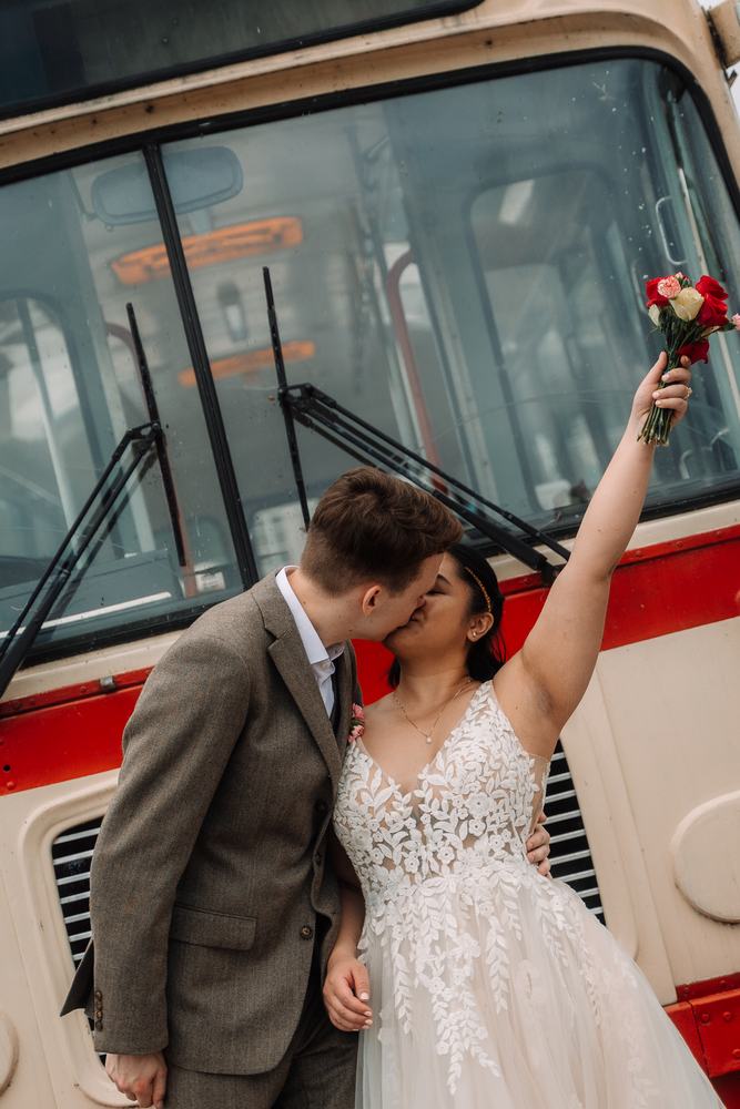 Couple celebrating by a vintage bus