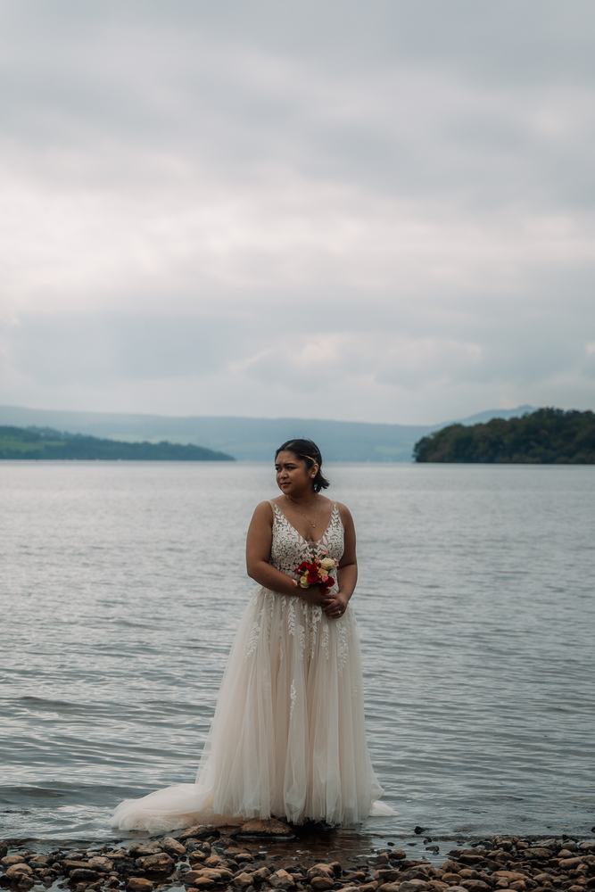 Bride standing at the edge of a loch