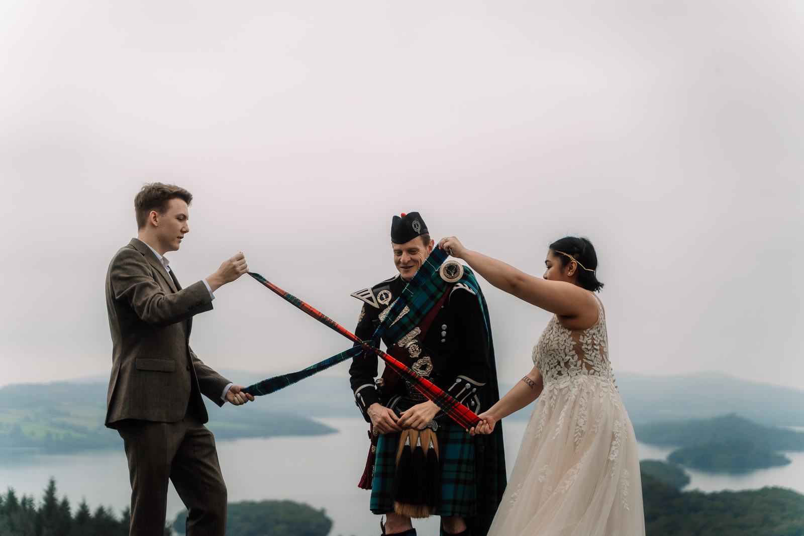 Bagpiper playing between the couple