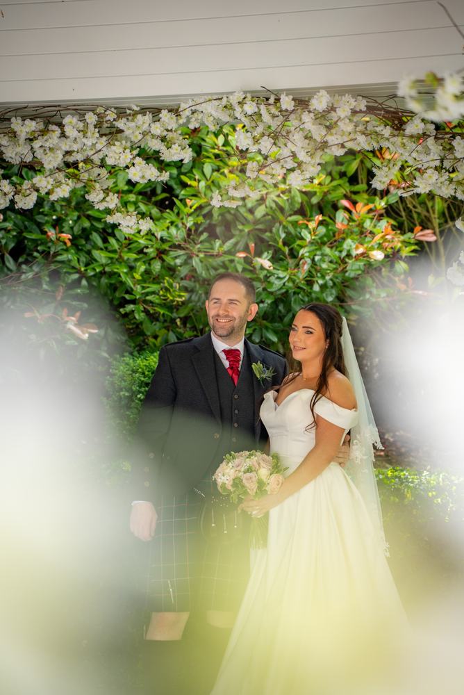 Couple framed by white flowers