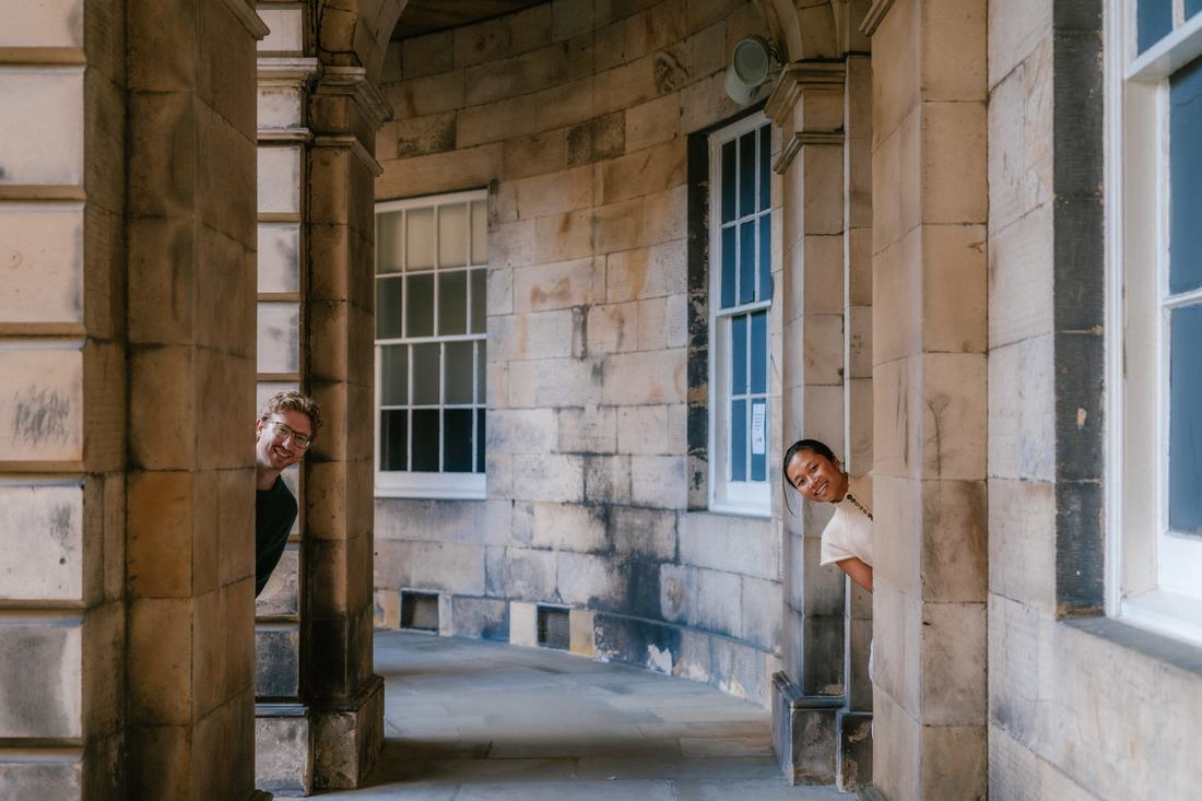 Couple peeking around a pillar