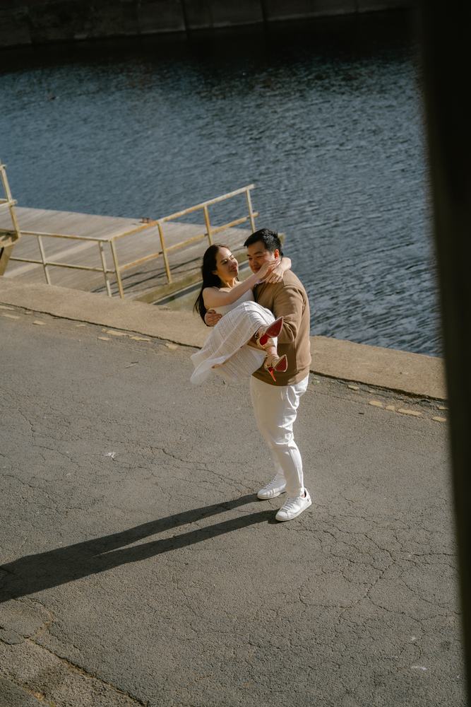Man lifting his partner on a riverside path