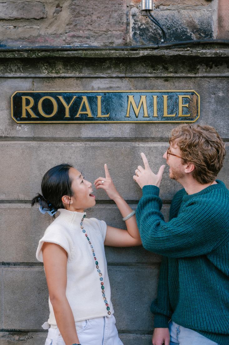 Couple pointing at a Royal Mile street sign