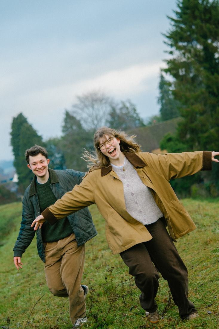 Couple running and laughing across a field
