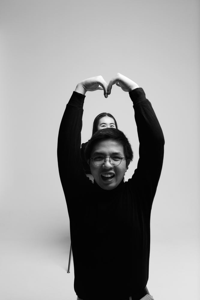 Stefan making a heart shape with his arms and grinning