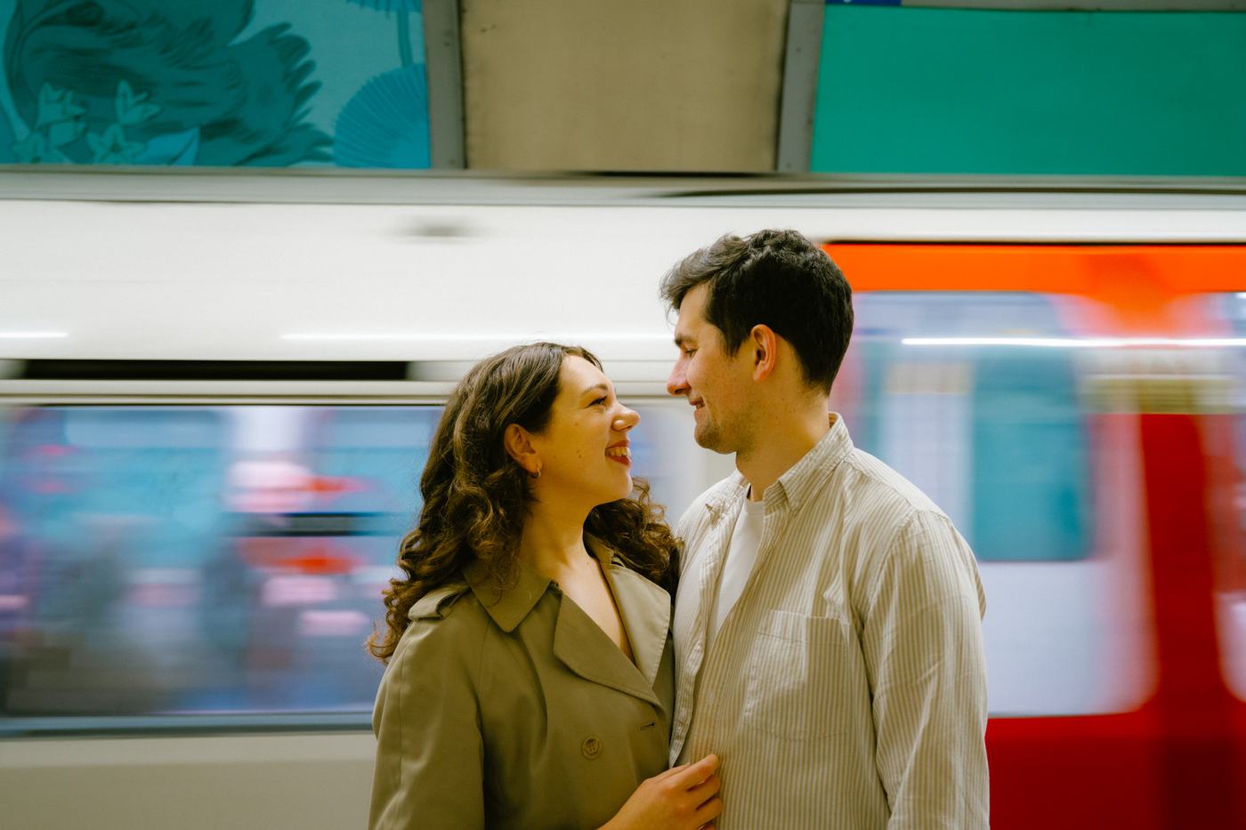 Couple on a Tube platform as a train rushes past