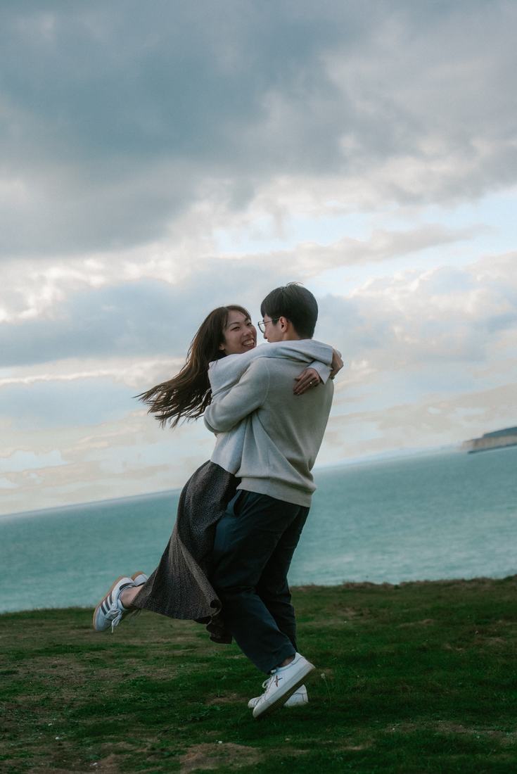 Couple spinning on a clifftop