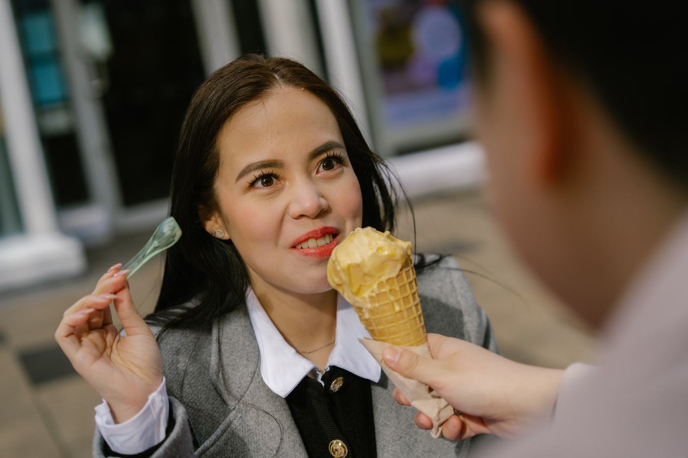 Woman offering an ice cream cone with a grin
